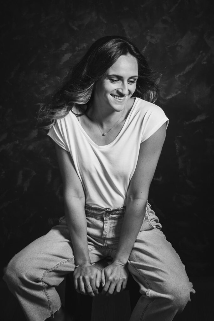 portrait d'une jeune femme assise souriante en studio de photographe professionnel