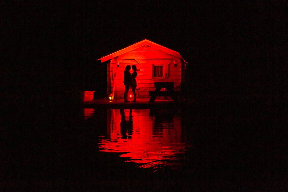 Couple en train de célébrer leur elopement sur l'eau en Savoie, photo de nuit où on distingue les silhouettes des mariées