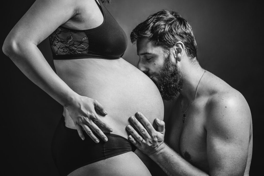séance photo grossesse avec un couple en studio, en noir et blanc faite un photographe portraitiste à Annecy