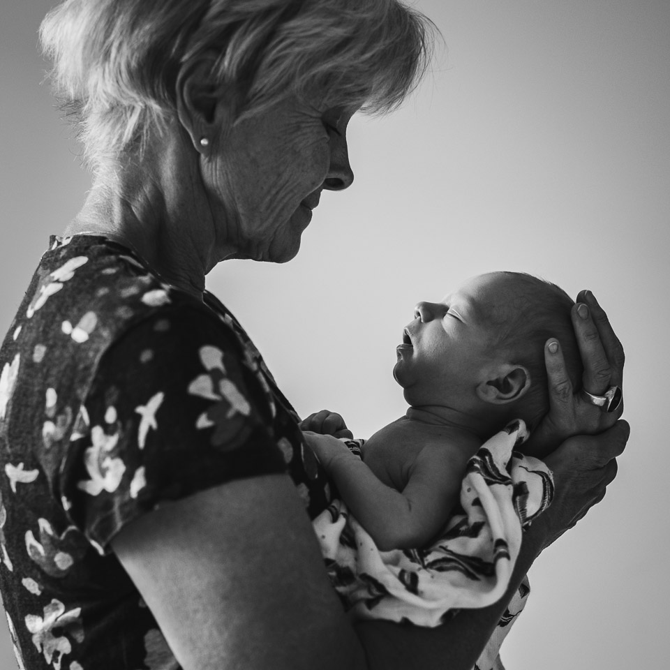 photo d'un nouveau né dans les bras de sa grand-mère