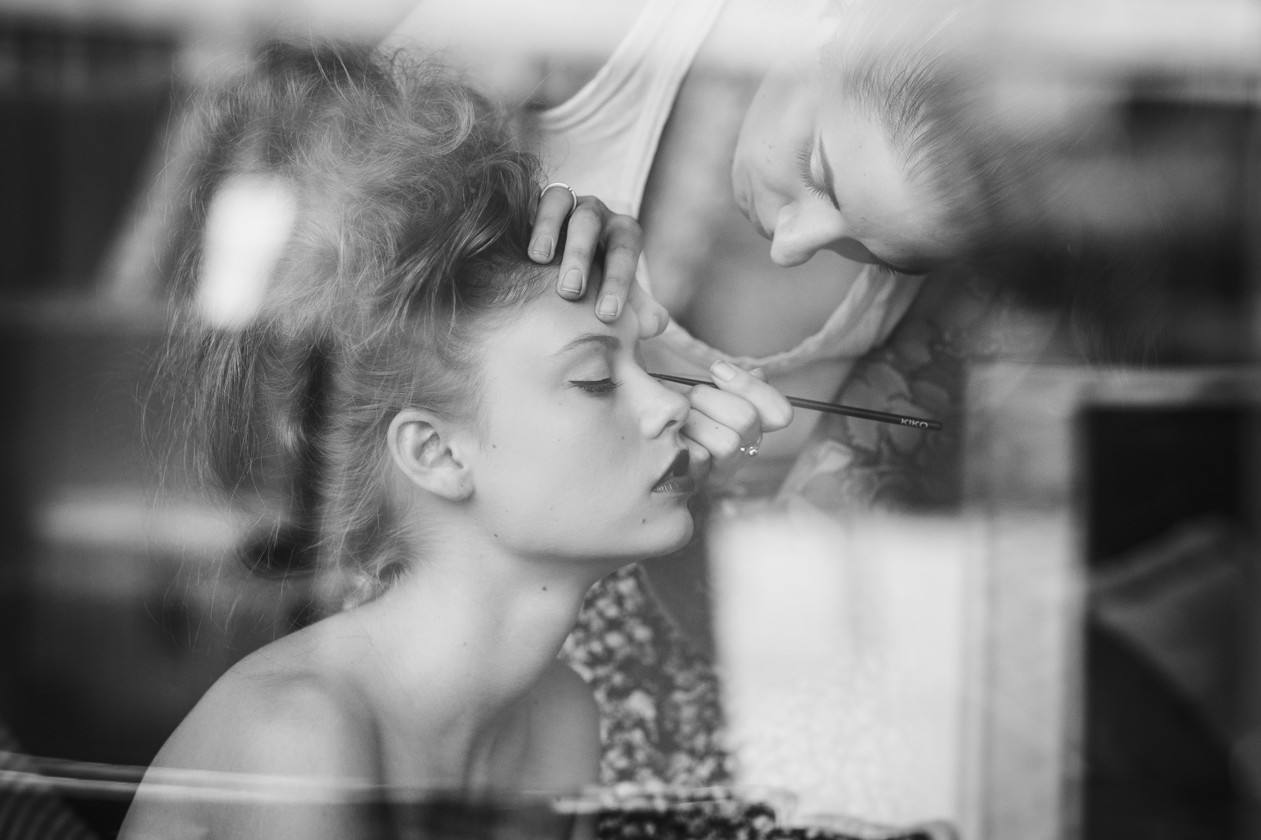 portrait backstage d'une femme en train de se faire maquiller