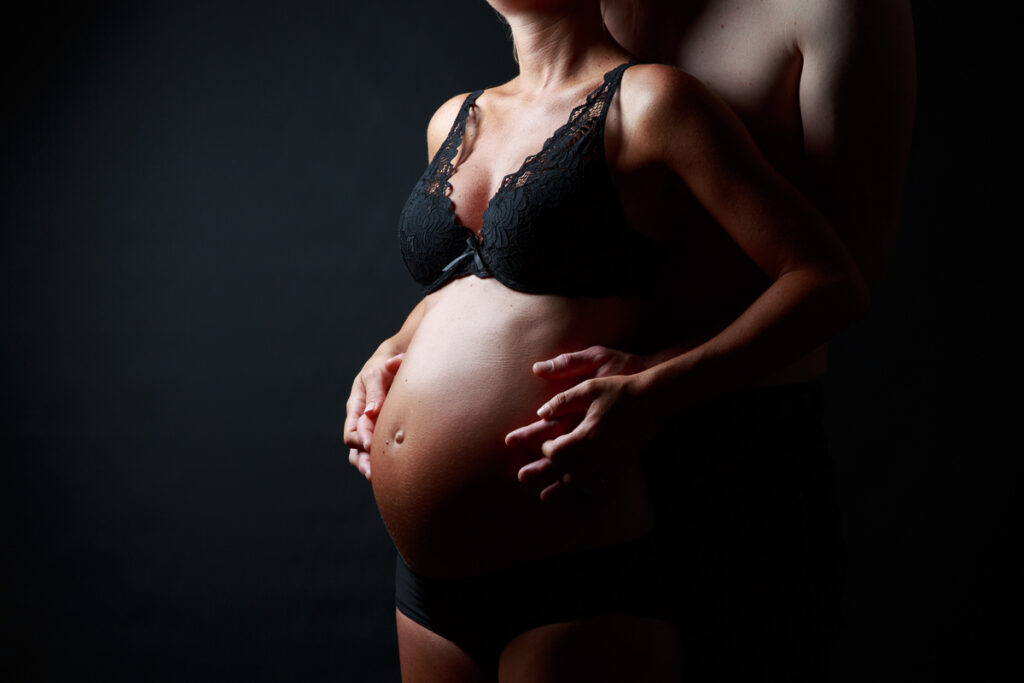 femme enceinte en lingerie accompagnée par son compagnon, prise par thomas vigliano photographe en Savoie et Haute Savoie