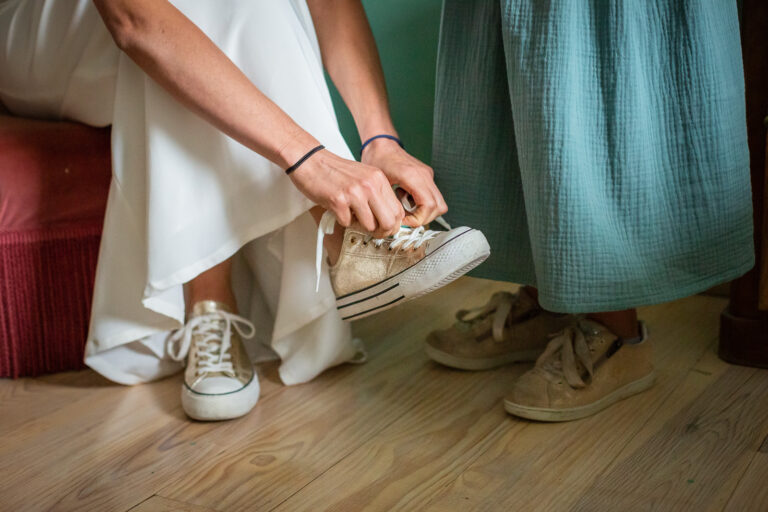 détail des préparatifs de la mariée qui lace ses baskets qu'elle portera pour son mariage