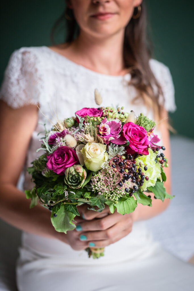 bouquet de la mariée avec des fleurs colorées vertes et violettes, photo en close up réalisée par un photographe spécialisé dans le mariage en savoie