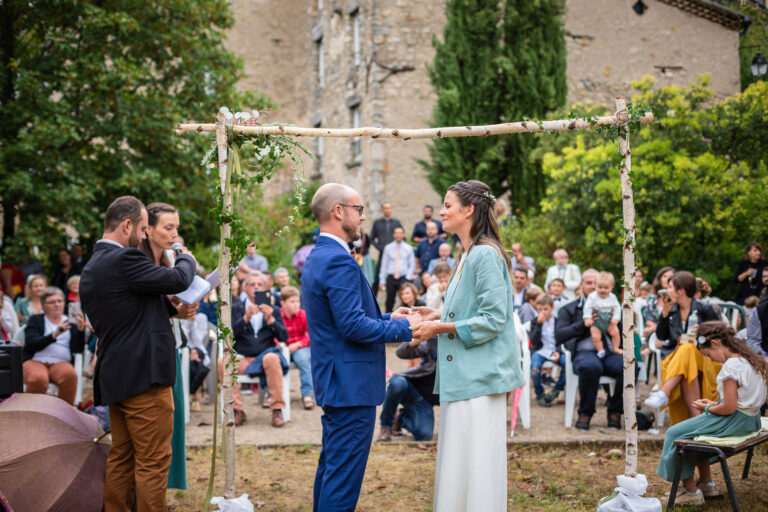 photo des mariés se tenant la main pendant leur cérémonie laïque de mariage dans un domaine