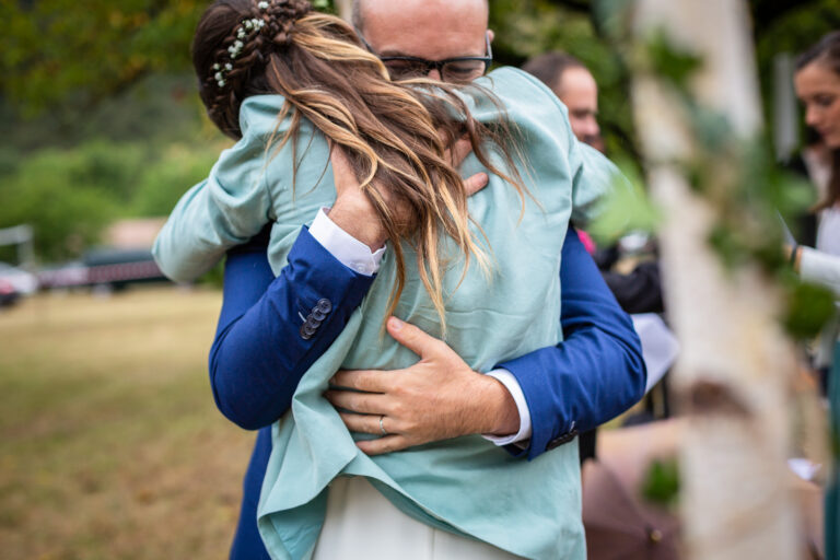 photo des mariés dans les bras l'un de l'autre pendant leur cérémonie laïque de mariage dans un domaine