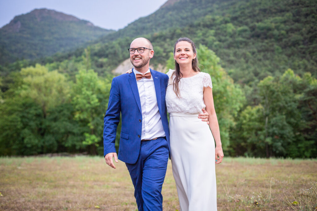 les mariés lors de leur séance couple le jour de leur mariage avec un photographe professionnel, avec en fond un paysage de verdure magnifique