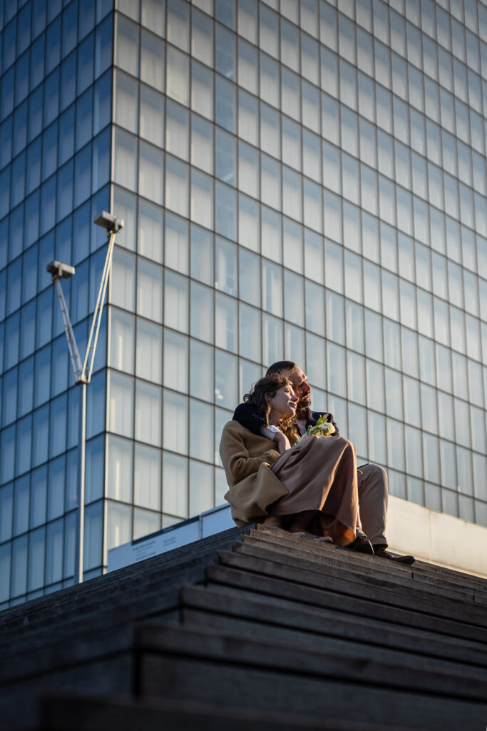 couple s’enlaçant sur les marches d'un bâtiment à Paris, lors d'une séance photo couple au coucher de soleil