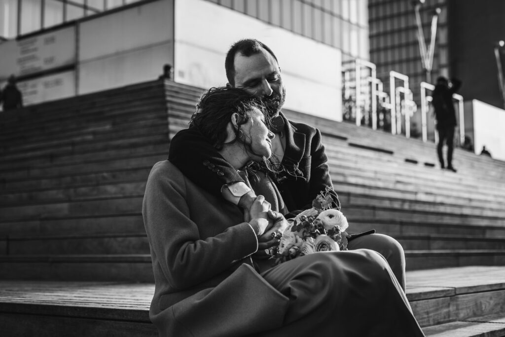 couple s’enlaçant sur les marches d'un bâtiment à Paris, lors d'une séance photo couple au coucher de soleil avec un photographe professionnel