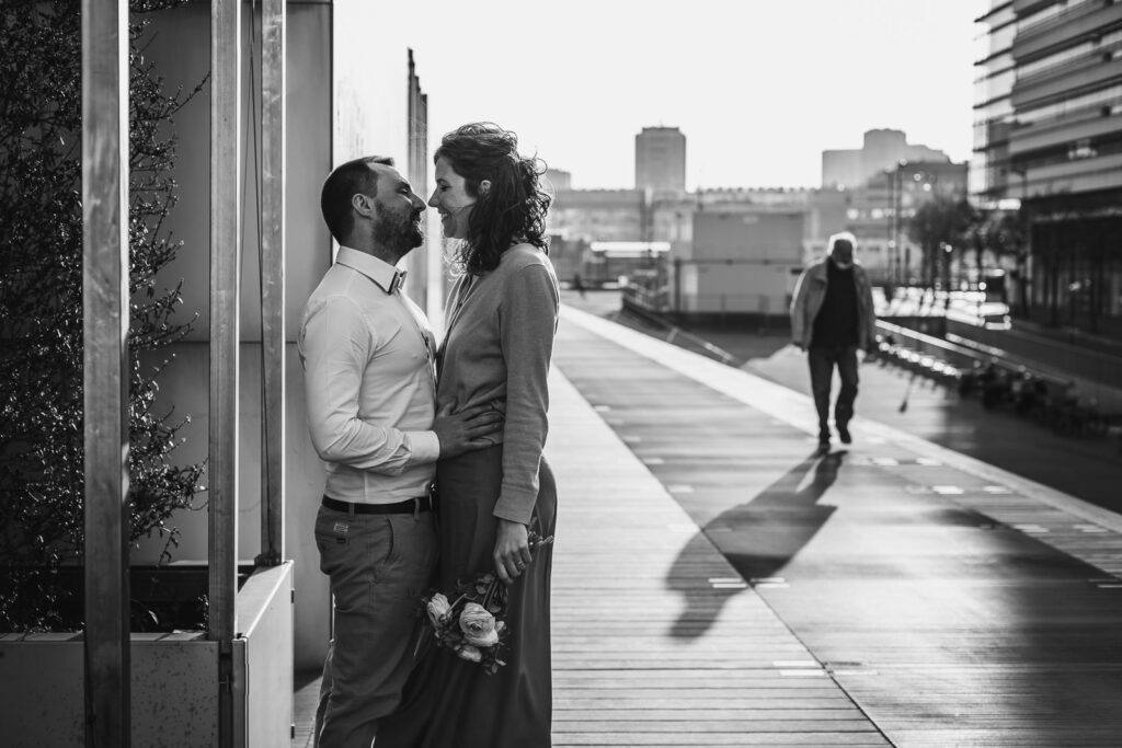 couple qui s'embrasse sur le parvis d'un bâtiment à Paris, lors d'une séance photo couple