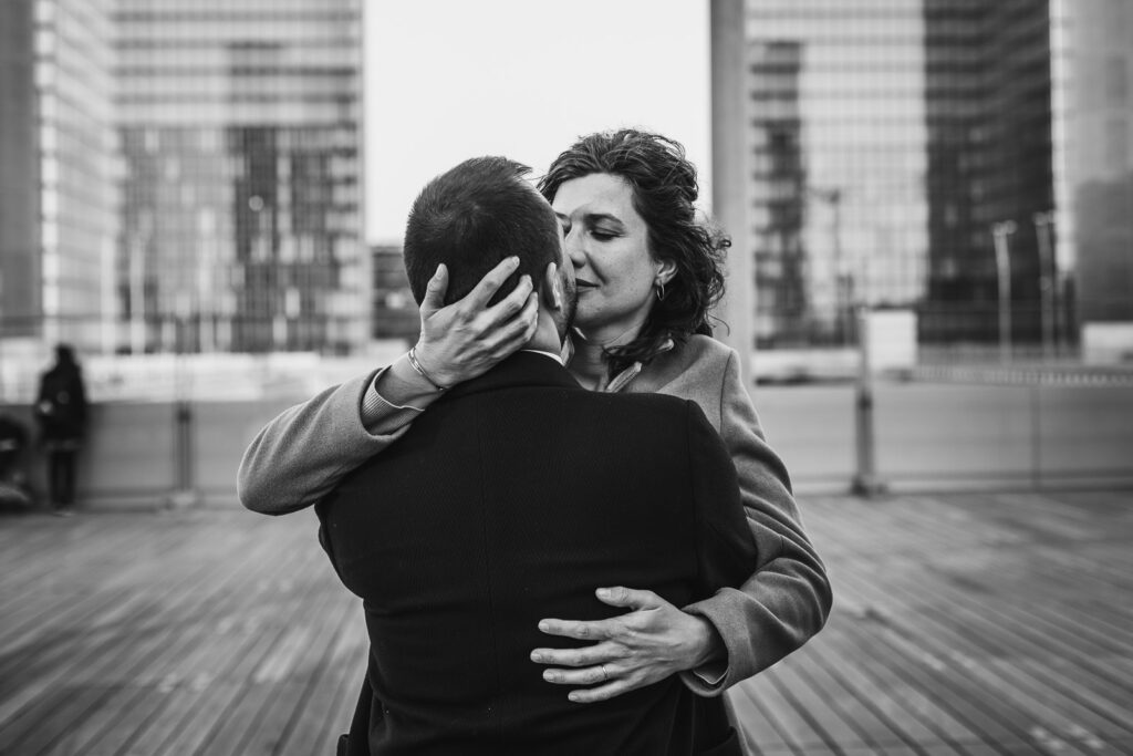photo pleine d'émotion d'un couple d'amoureux devant un bâtiment à Paris, lors d'une séance photo couple avec un photographe professionnel