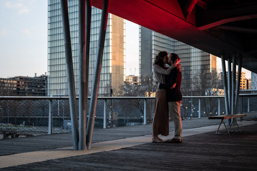 portrait artistique d'un couple qui s'embrasse sous un pont à Paris lors d'une session photo de couple avec un photographe professionnel