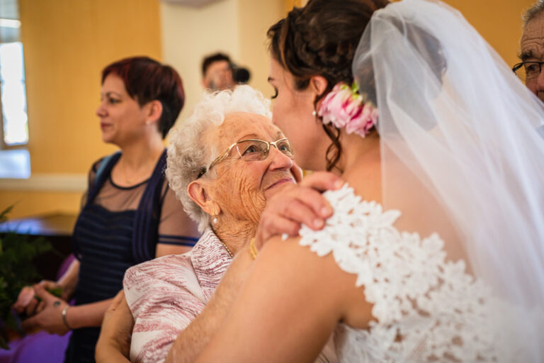 la mariée embrasse sa grand mère à l'église - photographe mariage isère pour garder les meilleurs souvenirs de votre mariage
