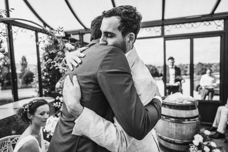 deux personnes se prennent dans les bras avec émotion lors d'une cérémonie de mariage