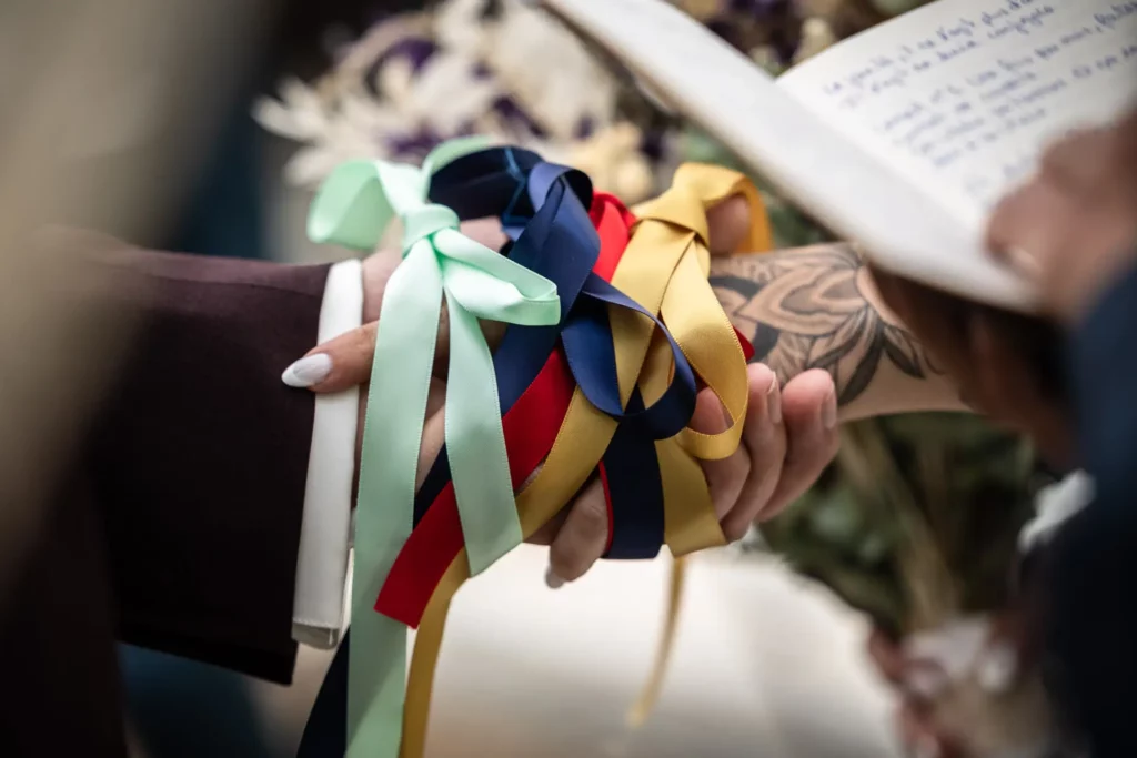 photo de détail des mains lors d'une cérémonie de mariage avec le rituel des rubans